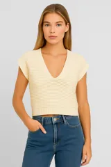 Musculosa color crema de acrílico con punto canalé, corte holgado y escote en V profundo.