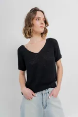 Remera tejida de manga corta, color gris claro, con escote en V y calce relajado. Presenta terminaciones acanaladas en mangas y ruedo.