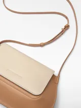 Mini bolso bandolera bicolor, con solapa y cierre magnético. Tiene un compartimento, tarjetero, asa larga regulable y logo grabado.
