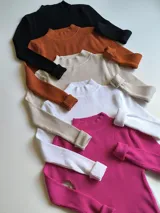 Pack de sweaters de punto acanalado con cuello alto en colores negro, naranja, beige, blanco y fucsia.