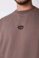 Buzo color beige de frisa con cuello redondo, mangas largas y logo bordado en el pecho.