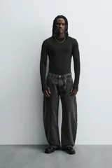 Camiseta de manga larga color crudo, corte ajustado y cuello redondo. Tiene aberturas en los puños y efecto lavado.