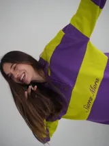 Sweater de hilo de algodón a rayas horizontales fucsia y verde, con cuello polo abotonado con botones de asta y bordado "Sierra Mora" en el pecho.