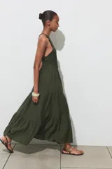 Vestido largo verde con estampado a cuadros, cuello halter con nido de abeja elástico y tirantes trenzados con abalorios.