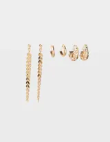 Set de tres pares de aros dorados: un par de aros largos con flechas colgantes, un par de aros tipo argolla lisa y un par de aros tipo argolla con strass.