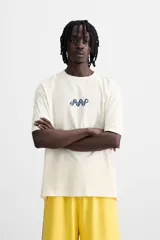 Camiseta blanca de corte relaxed fit, cuello redondo y manga corta. Estampado frontal con números y símbolos en azul.