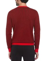 Sweater de punto con diseño jacquard bitono en rojo y negro, cuello redondo y logo bordado en el pecho.
