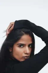 Top ajustado de punto acanalado suave, color negro, con cuello alto y mangas largas acampanadas.