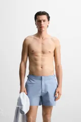 Bañador corto celeste de tejido técnico con cintura elástica ajustable con cordón interior y trabillas laterales. Cuenta con bolsillos frontales, bolsillo trasero con cierre de cremallera y forro interior.