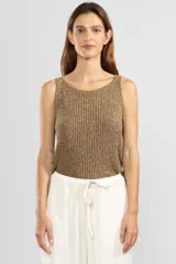 Musculosa sin mangas tejida en Italia en punto canalé con mezcla de viscosa e hilos metálicos Lurex color dorado. Con escote bote y calce cómodo.