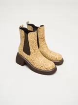 Botas Chelsea color beige con estampado floral, elástico lateral marrón y suela track color marrón.