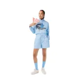 Buzo blanco de algodón con cuello redondo, puños y cintura acanalados. Estampado frontal con el logo de Lacoste y un cocodrilo vestido con ropa de ciclista andando en bicicleta.