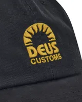Gorra de béisbol negra con logo Deus Ex Machina bordado en dorado en el frente.