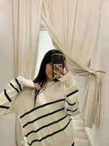 Sweater de tejido Bremer negro con rayas horizontales color tostado, de corte holgado y cuello redondo.