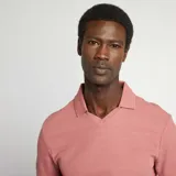 Remera rosa de piqué con cuello polo en V y mangas cortas.
