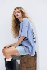 Remera celeste de corte amplio con cuello redondo y estampado pequeño en el pecho.