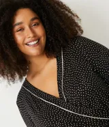 Pijama mono largo de viscolycra con estampado de lunares, escote en V cruzado y mangas largas con ribete en contraste. Diseño Curve & Plus Size.