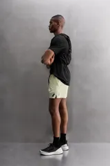 Shorts deportivos color verde oliva confeccionados en tejido técnico ligero y elástico. Cuenta con forro interior, cintura elástica ajustable con cordón, bolsillos laterales, bolsillo de seguridad en espalda con cierre de cremallera, bajo con aberturas laterales y logo estampado en la pierna.