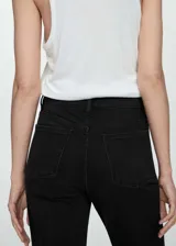 Pantalón de jeans negro de corte mom-fit, tiro alto, cinco bolsillos, trabillas y cierre con cremallera y botón.