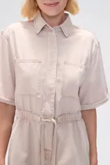 Mono corto blanco de algodón, con cuello camisero, cierre frontal con botones, mangas cortas y bolsillos.