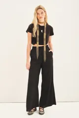 Pantalón palazzo negro de tiro alto con cintura elastizada y bolsillos diagonales.