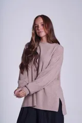 Sweater color beige de tejido de punto acanalado, con cuello redondo y mangas largas. Tiene corte holgado y aberturas laterales en el ruedo.