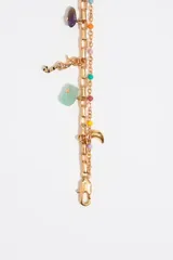Pulsera dorada de doble cadena con charms colgantes de diferentes formas y colores, incluyendo piedras, perlas y dijes metálicos.