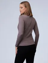 Polera de tejido rib de color blanco, con cuello alto y ajuste cómodo, ideal para usar sola o como capa.