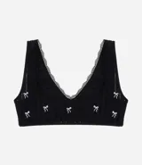 Soutien top negro seamless y texturizado, con breteles anchos fijos, escote cuadrado en la espalda, detalle de encaje y bordados de lacitos.