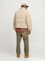Campera puffer color beige de tela tipo teddy, con cuello alto, cierre frontal con cremallera, bolsillos laterales y puños elásticos.