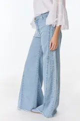 Pantalón palazzo color beige con detalles de crochet en los laterales.