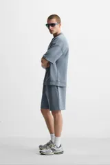 Sudadera negra de corte relaxed fit, confeccionada en tejido interlock de algodón con elasticidad. Tiene cuello redondo, manga corta y bajo acabado en rib.