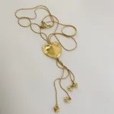 Collar dorado con cadena fina y dije grande en forma de corazón irregular, con tres dijes pequeños de corazón colgando.