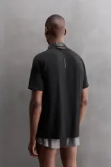 Camiseta deportiva verde militar confeccionada en tejido estructurado, ligero y elástico. Tiene cuello redondo, manga corta y bajo con aberturas laterales. Incluye logo estampado en el bajo.