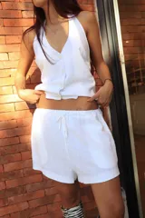 Short blanco con corte a la cintura y detalle de panel lateral en color beige.