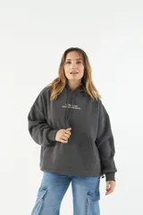 Canguro oversize de felpa gris, con capucha ajustable, bolsillo frontal y estampado en la parte delantera y trasera.