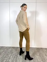 Pantalón de vestir color camel, de corte recto, con cintura plisada, bolsillos laterales y traseros. Se ajusta a la cintura con cinturón de animal print.