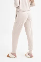 Pantalón de punto color beige, con cintura elástica y detalles de bolsillos.