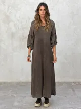 Vestido largo color marrón, de corte suelto, con mangas largas abullonadas y escote en V.