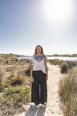 Blusa blanca de algodón con bordados florales en azul marino en el frente y las mangas.