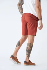 Bermuda de gabardina azul marino con logo bordado, bolsillos laterales y traseros, cierre con cremallera y botón, y presillas para cinturón.