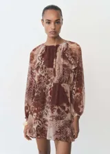 Vestido corto de gasa con estampado animal print en tonos marrones y beige, con volantes en la falda y detalle fruncido en el cuello. Diseño recto, semitransparente y de manga larga.