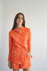 Short de lino y algodón color naranja con estampado de hojas y flores en tonos claros, con cintura elástica.