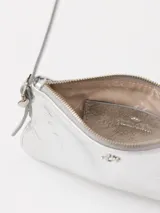 Mini cartera plateada de cuero con correa fina del mismo material y aplique metálico JCH en el frente.