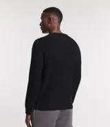 Suéter negro de algodón con cuello redondo y textura de punto.