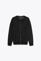 Chaqueta de punto fino negra con lunares blancos, cuello redondo, manga larga, terminaciones en rib y cierre frontal con botones.