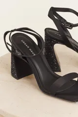 Sandalias negras de tacón bloque con pulsera al tobillo y punta cuadrada.