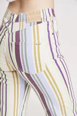 Pantalón jean de corte wide leg con estampado de rayas verticales en tonos lila, verde y amarillo.