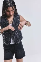 Chaleco negro de jean con bordados y apliques plateados.