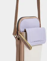 Porta celular de cuerina texturada con bolsillo frontal con solapa, correa regulable, acceso mediante cierre superior y puller de cuerina estampada, solapa con broche con botón para cerrado y tag de metal.